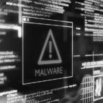 A digital screen displays a warning triangle with an exclamation mark and the word MALWARE in bold, surrounded by glowing lines and computer code, representing a cybersecurity threat and risk of data breaches.