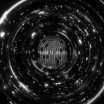A glowing orange fingerprint is centered within a circular digital tunnel of blue and orange lights, suggesting advanced technology and Two-Factor Authentication to help protect companies in Portland through biometric identification.