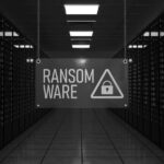 A sign reading RANSOMWARE with a lock icon hangs in a Portland server room filled with rows of servers lit by red lights, conveying the looming threat of ransomware attacks.