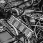 A close-up of assorted computer components, including circuit boards, a RAM stick, and tangled cables. The cluttered arrangement highlights reasons to upgrade when faced with failing technology or planning a technology upgrade.