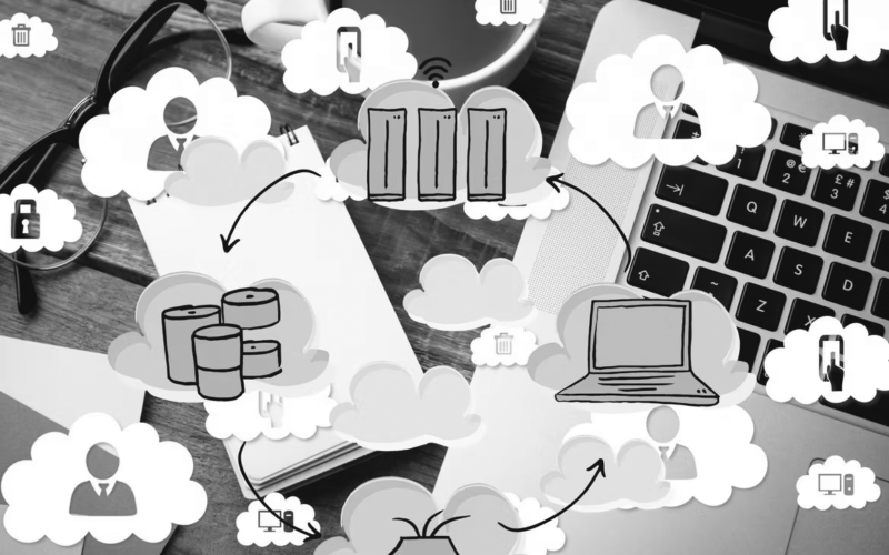 A desk with a laptop, coffee, glasses, and a notebook, overlaid with cloud computing icons—servers, databases, people, and security locks—highlighting data backup and business recovery plan connections.